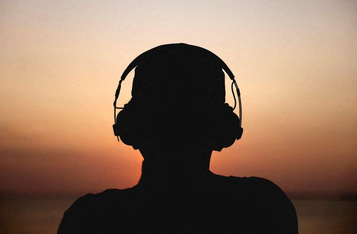 A man watches the sunset while wearing a headphone and listening to music, in Colombo, Sri Lanka February 23, 2023. REUTERS/Dinuka Liyanawatte