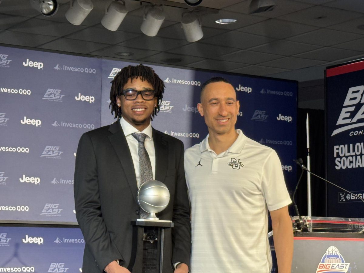 Shaka Smart stands with Nigel James Jr. on Wednesday after he receives his Big East freshman of the year award.